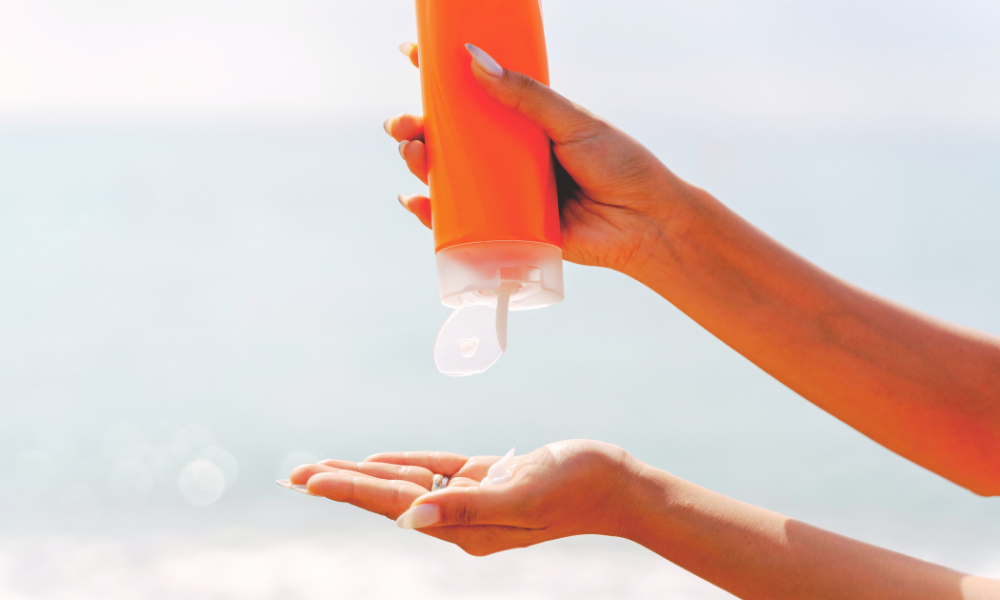 pessoa aplicando protetor solar no braço